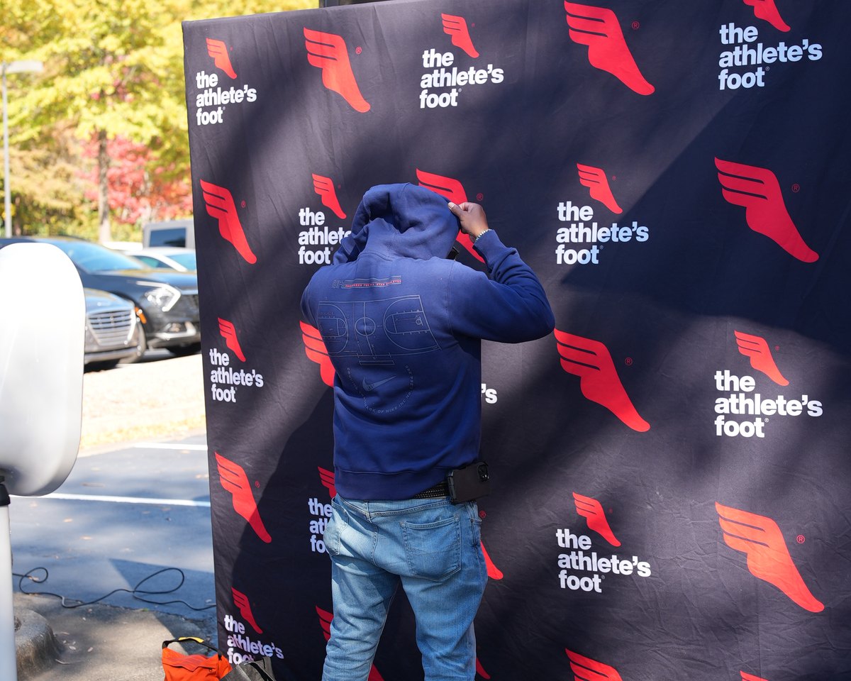 A guest at the branded photo backdrop during an in-store brand activation