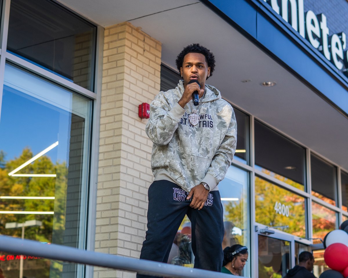 A host on the mic at a community event outside the store