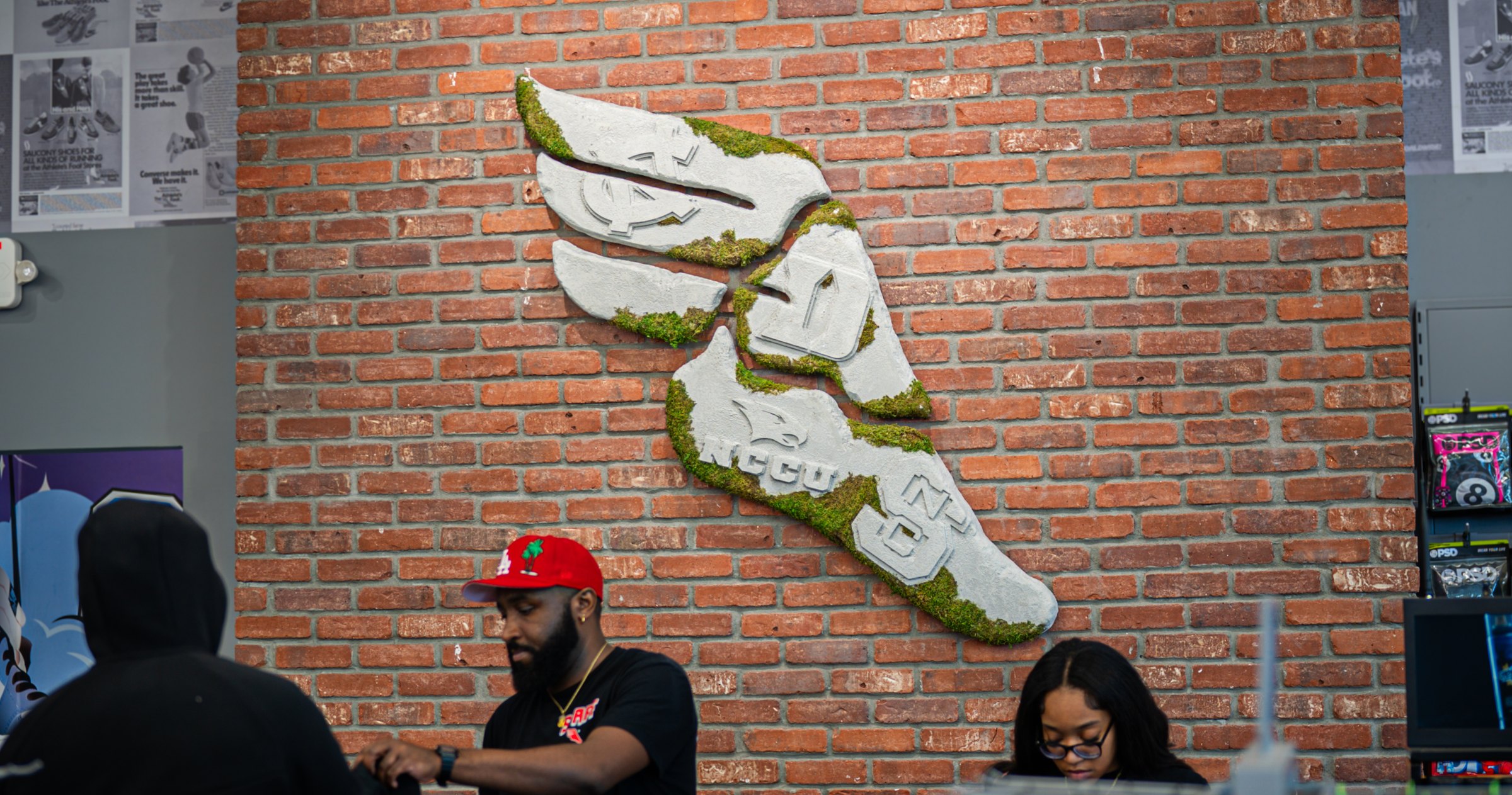 The winged-foot logo on the brick wall inside the store