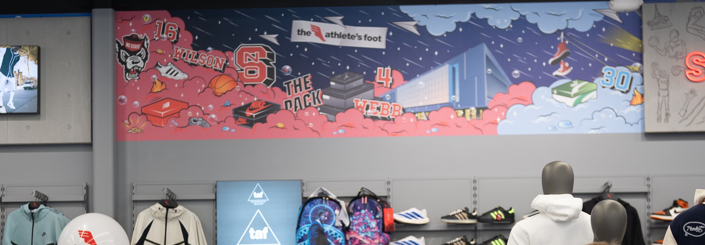 The mural wall and retail floor inside The Athlete's Foot Raleigh store